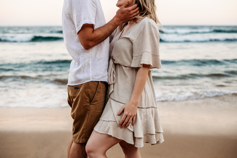 Family Photographer, A couple embrace each other at the beach's tide
